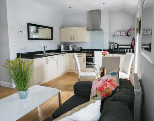 a kitchen and living room with a couch and a table at The Green House classic 2 bedroom apartment in Harrogate