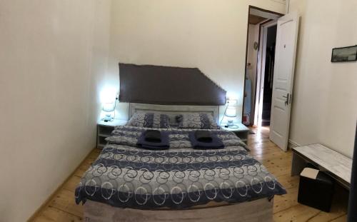 a bedroom with a large bed with two lamps at Le Petit in Tbilisi City