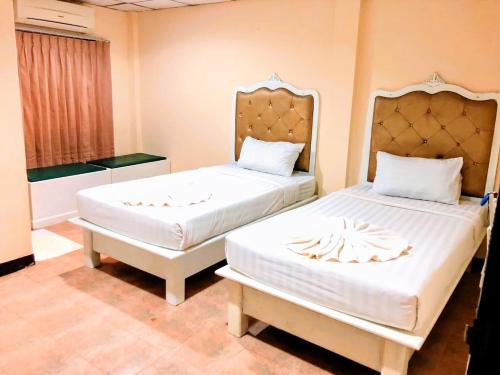 two beds in a room with two bedsitures at Golden Bee PhiPhi in Phi Phi Don