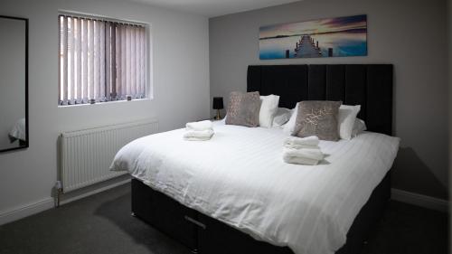 a bedroom with a large bed with white sheets and pillows at City Lodge Serviced Apartments Worcester City Centre - Parking in Worcester