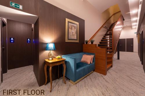a first floor hallway with a blue couch and stairs at Center Ljubljana in Ljubljana