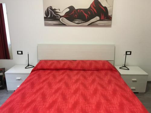 una camera con letto rosso e 2 comodini di Matt5, il tuo angolino triestino a Trieste
