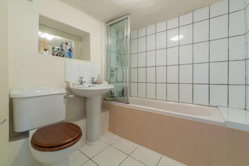 uma casa de banho com um WC, um lavatório e uma banheira em No33 BRACKEN BOUTIQUE COTTAGE em Brancaster