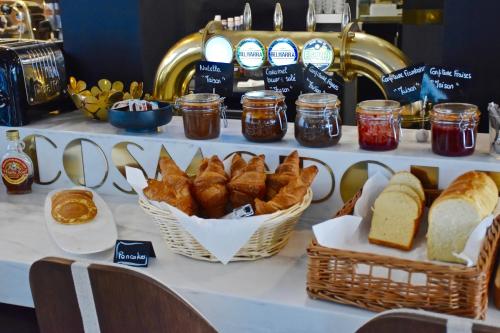 a table with bread and jams and baskets of bread at Hôtel Cosmopolitain in Biarritz