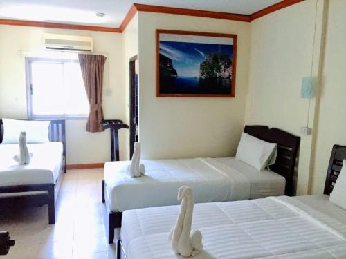 a hotel room with two beds with swans on them at Golden Bee PhiPhi in Phi Phi Don
