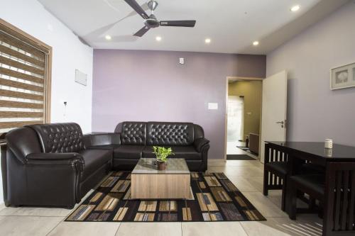 uma sala de estar com um sofá e uma mesa em sahara suites em Cochin