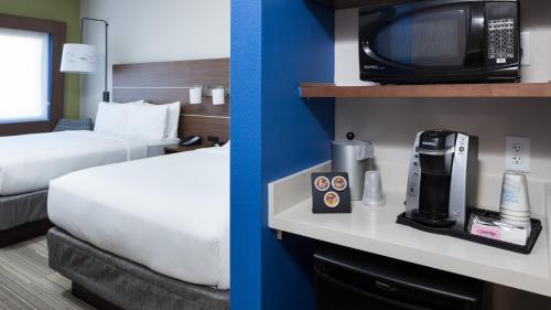 a hotel room with a bed and a microwave at Holiday Inn Express & Suites Orlando At SeaWorld by IHG - With Free Shuttle Service to SeaWorld Parks in Orlando