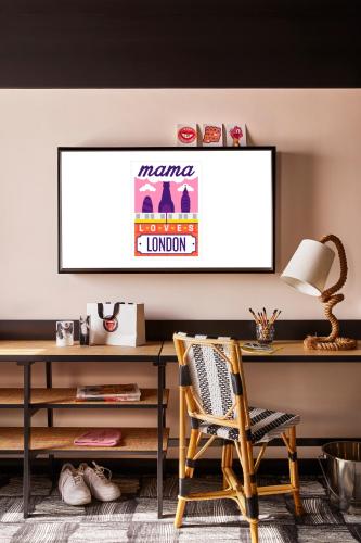 a desk and a chair in a room at Mama Shelter London - Shoreditch in London
