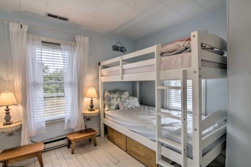 a bedroom with two bunk beds and two windows at Chincoteague Charm Escape with Bikes and Yard Games! in Deep Hole