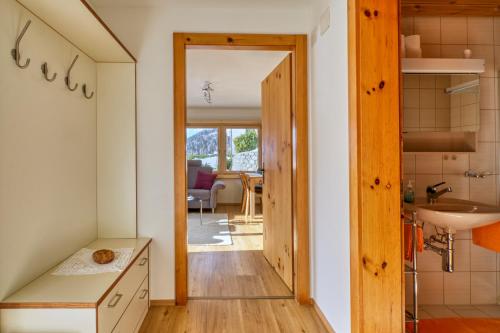 a room with a door leading to a kitchen with a sink at Chasa Plajet in Ramosch