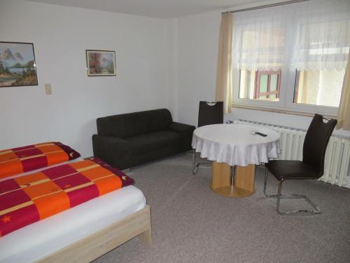 バート・フランケンハウゼンにあるFerienwohnung & Zimmervermietung Wolfのベッドルーム1室(ベッド1台、テーブル、ソファ付)