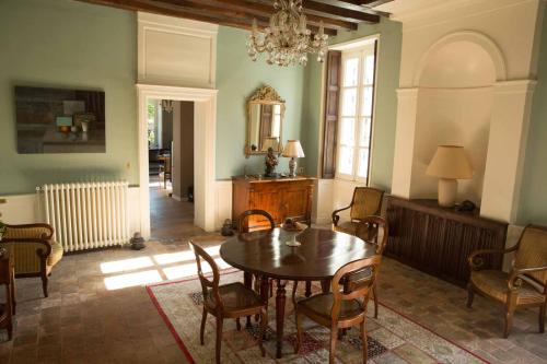 een eetkamer met een tafel, stoelen en een spiegel bij Le Clos des Péziers in Vineuil
