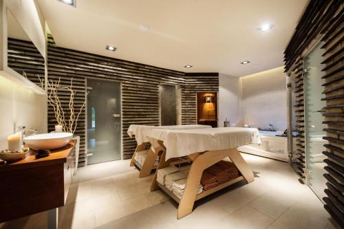 a bathroom with a table and a sink and a tub at Sandra Spa Karpacz & Aquapark in Karpacz