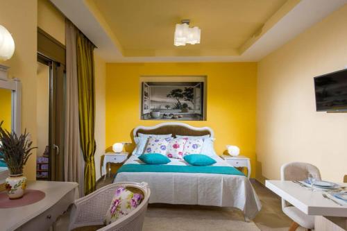 um quarto com uma cama e uma parede amarela em Yiasemi Luxury Suite em Mália