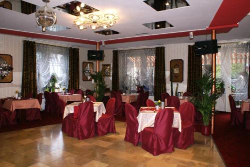 un comedor con sillas y mesas rojas en un restaurante en Parkhotel Sonne, en Schönau im Schwarzwald