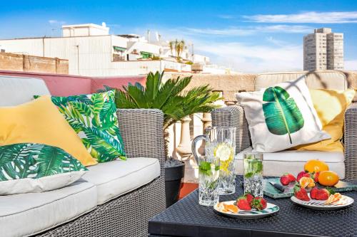 un patio con sedie in vimini e un tavolo con frutta. di Glam Penthouse Barcelona a Barcellona