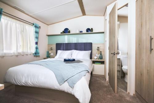 a bedroom with a bed and a bathroom with a toilet at Siblu Camping de Oase in Renesse