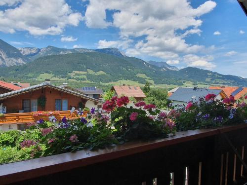 a balcony with a bunch of flowers and mountains at Appartement am Hauser Kaibling in Haus im Ennstal