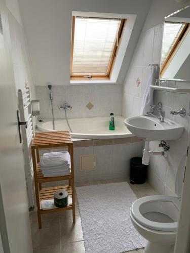 La salle de bains est pourvue d'un lavabo, d'une baignoire et de toilettes. dans l'établissement Penzion Holiday, à Trnava