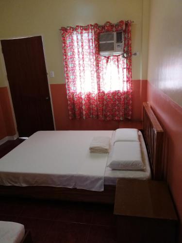 a small bedroom with a bed and a window at ISLET VIEW Pension House ( Formerly Island View Pension House ) in Oslob