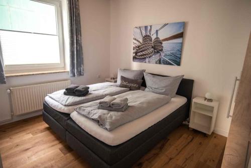 um quarto com uma cama com duas toalhas em Ferienwohnung-2-Strandnah-und-mit-Strandkorb-im-Haus-Seeluft-in-Duhnen em Cuxhaven
