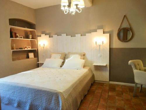 a bedroom with a bed and a chandelier at Un Patio en Luberon in Ansouis