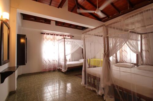 a bedroom with two bunk beds and a window at Ritas Hotel in Hikkaduwa