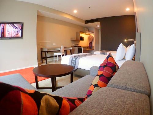 a hotel room with two beds and a table at De Elements Business Hotel Damansara in Damansara Perdana
