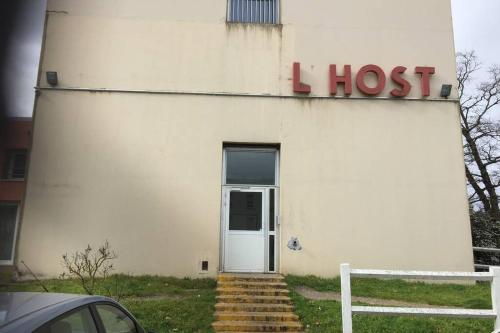a white building with a sign that reads l hottest at Appartement design tout confort (parking gratuit) in Gradignan