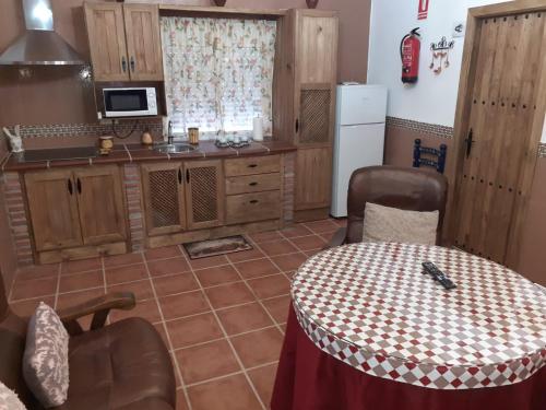 a kitchen with a table, chairs, and a refrigerator at Cueva El Jaraiz in Guadix