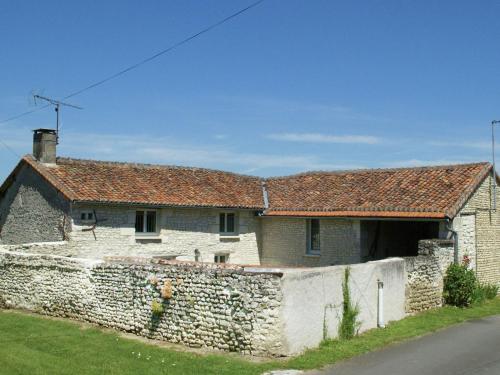 an old stone house with a stone wall at Farmhouse with garden near Richelieu in Chaveignes