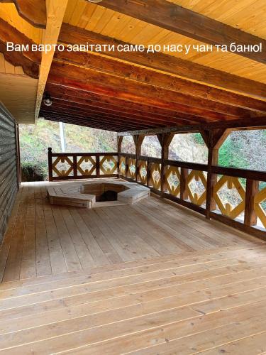 a wooden pavilion with a wooden roof and a wooden floor at Терношорська Лада in Snidavka