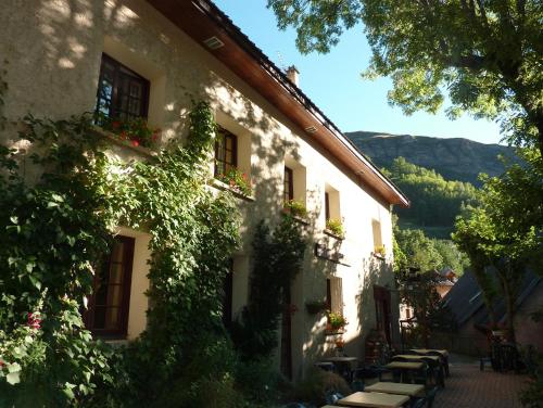 a building with ivy growing on the side of it at Hotel Auberge Edelweiss in La Grave