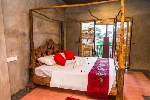 a bedroom with a canopy bed with red pillows at Negombo Boutique Villa in Negombo
