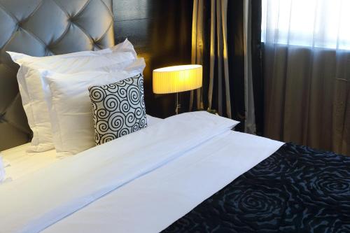 a bedroom with a bed with white sheets and pillows at Mövenpick Hotel Casablanca in Casablanca