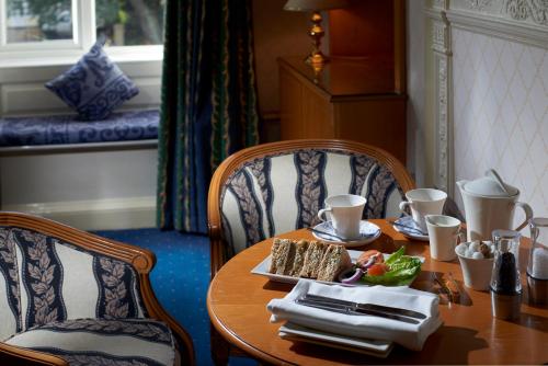 a wooden table with a plate of food on it at Les Rocquettes Hotel in St Peter Port