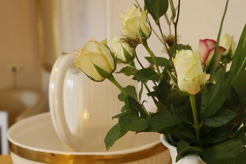 a vase with roses in it sitting on a table at Herberg Oud Holset in Lemiers