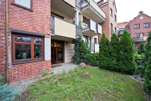 a brick house with a yard in front of it at Niewielki pokój jedno lub dwuosobowy w dużym mieszkaniu w Gdańsk Wrzeszcz ul Smoluchowskiego koło Akademii Medycznej - cooliving in Gdańsk