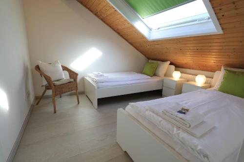 a attic bedroom with a bed and a window at Holledau-Apartments Familie Gmeineder in Osterwaal