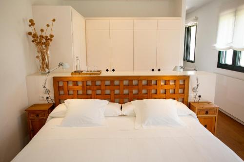a bedroom with a large white bed with two pillows at Finca Atalis - Adults Only in Santo Tomás