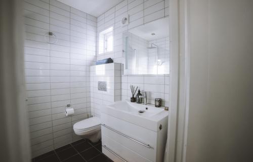 a white bathroom with a sink and a toilet at Fab scenery in Ballstad