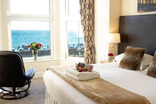 1 dormitorio con 1 cama con silla y ventana en Ellan Vannin Hotel, en Douglas