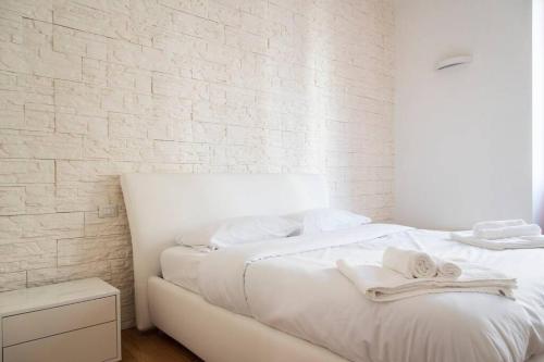 biała sypialnia z białą ceglaną ścianą w obiekcie YouHosty - Ranzoni 4 w Mediolanie