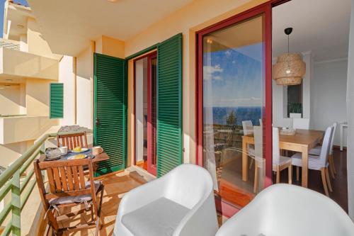 a room with a balcony with a table and chairs at Garajau IV by An Island Apart in Caniço