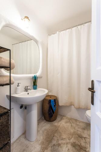 a white bathroom with a sink and a mirror at Sunset Villa Iza in Agios Ioannis Mykonos