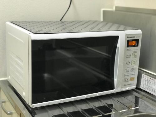 a microwave oven sitting on top of a counter at Hostel 1010 TOKYO in Tokyo