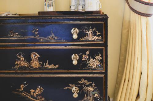 a black dresser with intricate designs on it at Melbourne Lodge in Welwyn