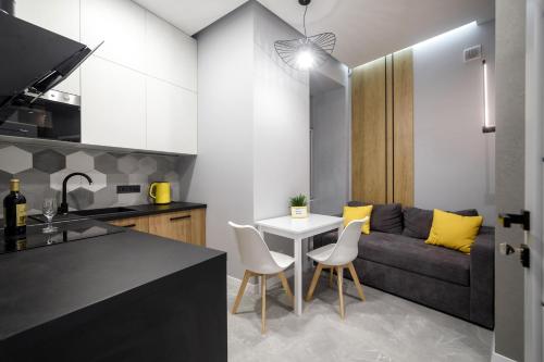 a kitchen and living room with a table and a couch at Royal apartment on Hmelnytskogo 37 in Lviv