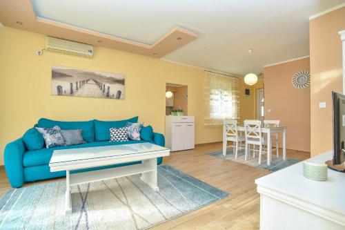a living room with a blue couch and a table at Branka Apartments in Tivat
