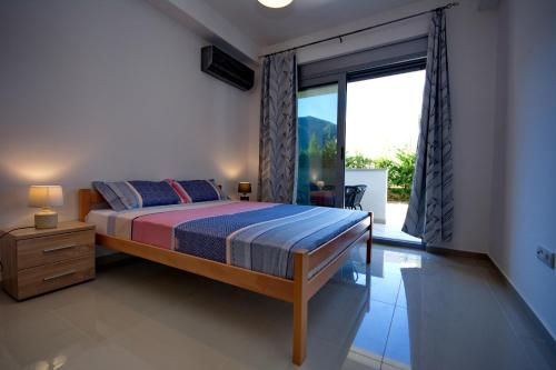 ein Schlafzimmer mit einem Bett und einem großen Fenster in der Unterkunft Apartment Dobrota-1 in Tomići